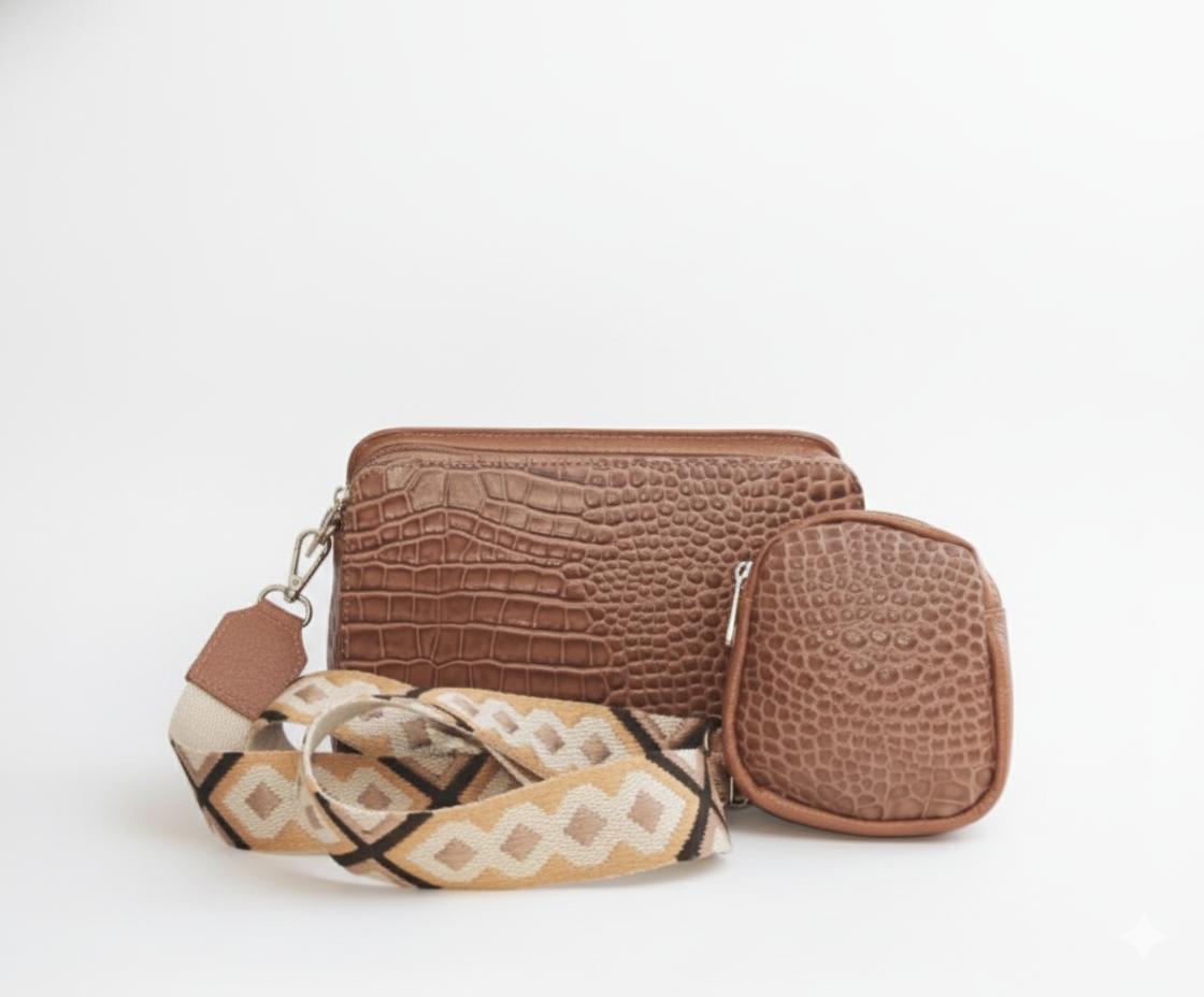 Leather Crossbody bag with embossed texture and patterned strap.